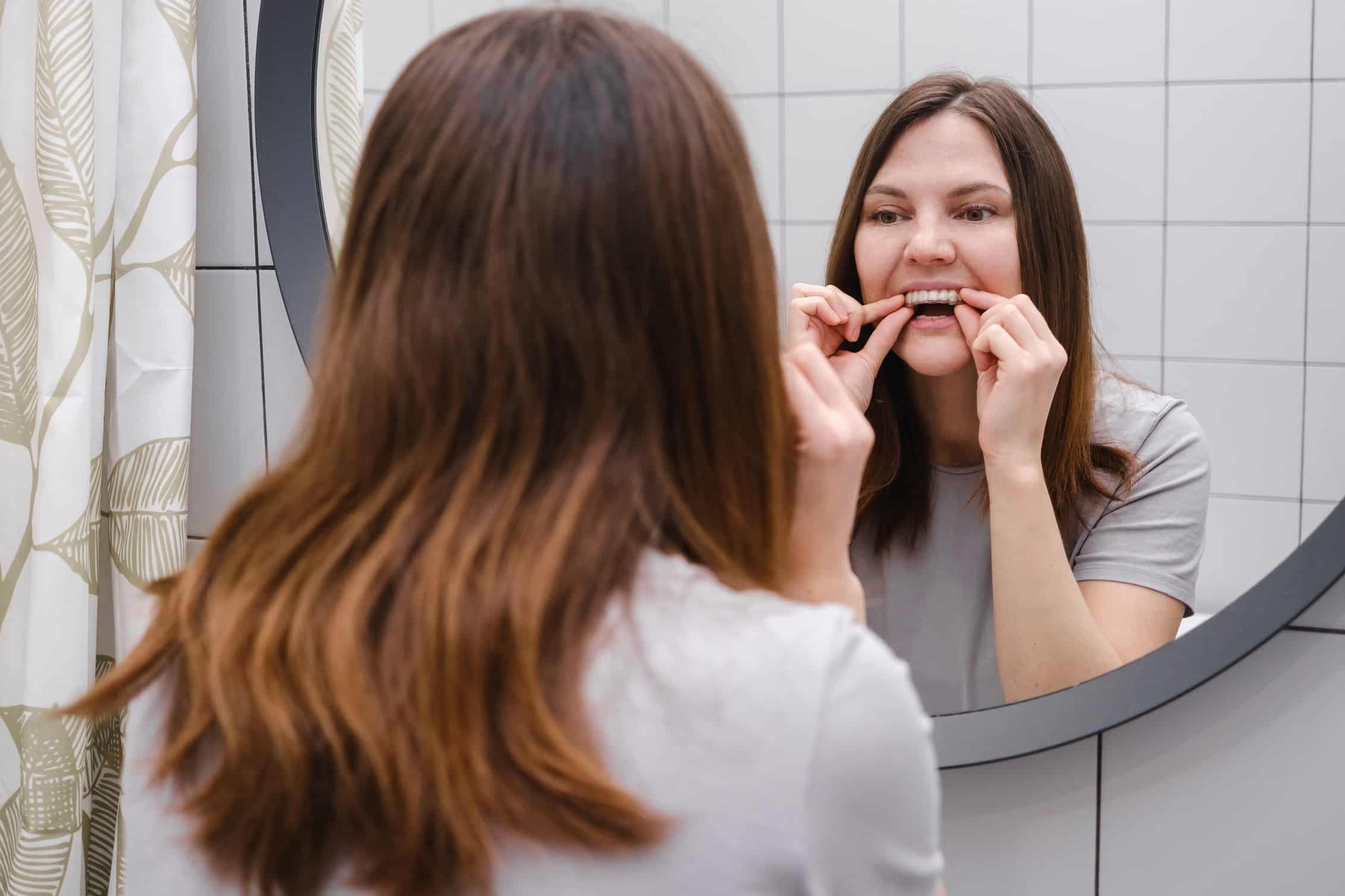 A,Woman,In,Front,Of,A,Mirror,In,The,Bathroom