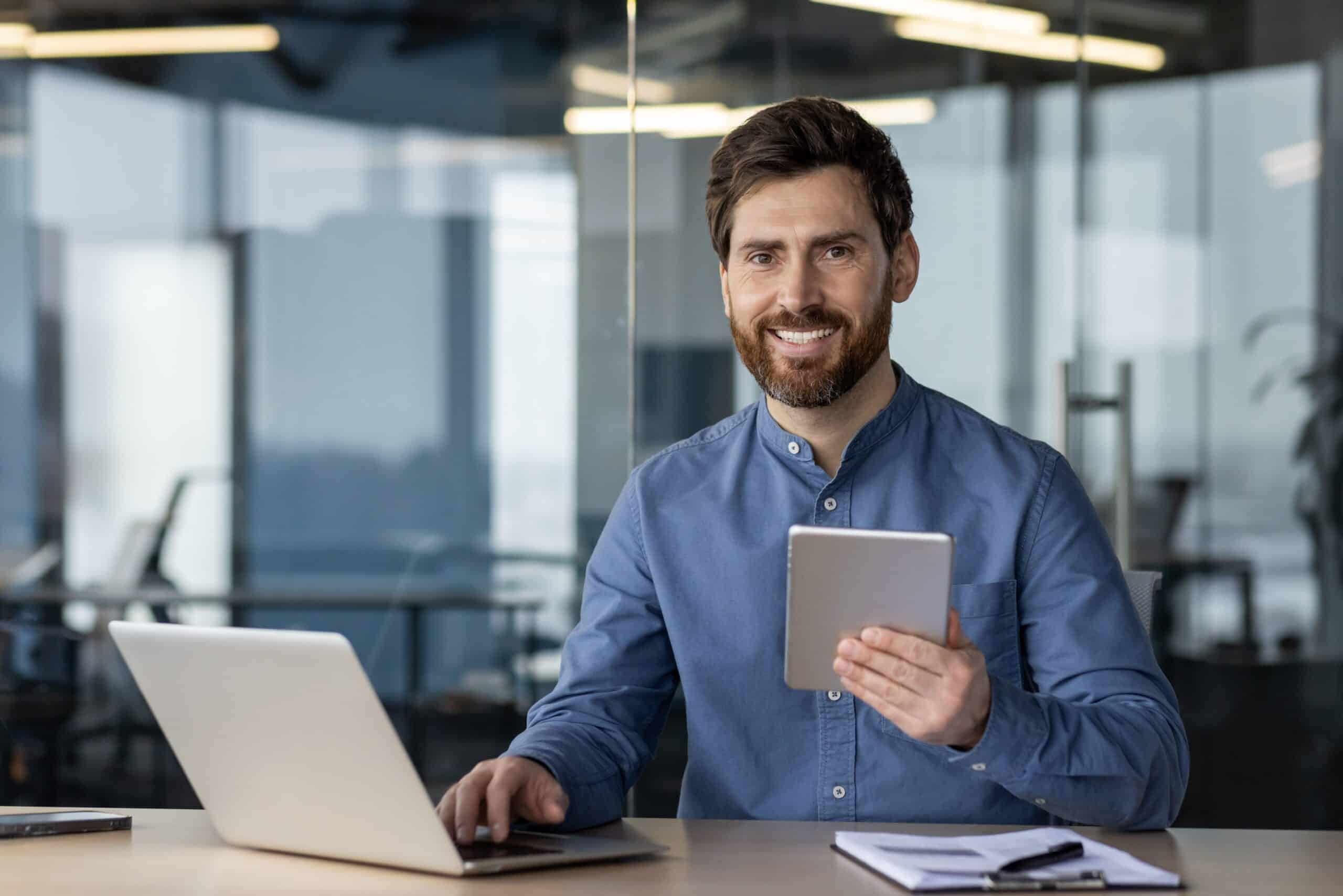 Portrait,Of,A,Smiling,Young,Man,Sitting,At,An,Office